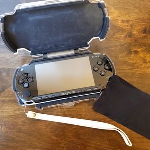 PSP (Sony) with a protective case and 4 games